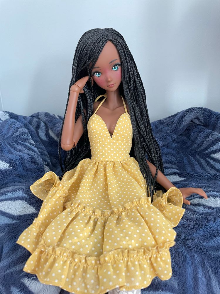 Smart Doll - fortitude. Mechanically jointed doll in an anime style with long dark braids wearing a yellow tie top dress 