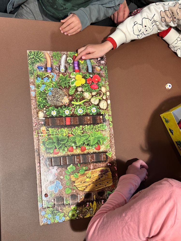 Board game with hands of three children 