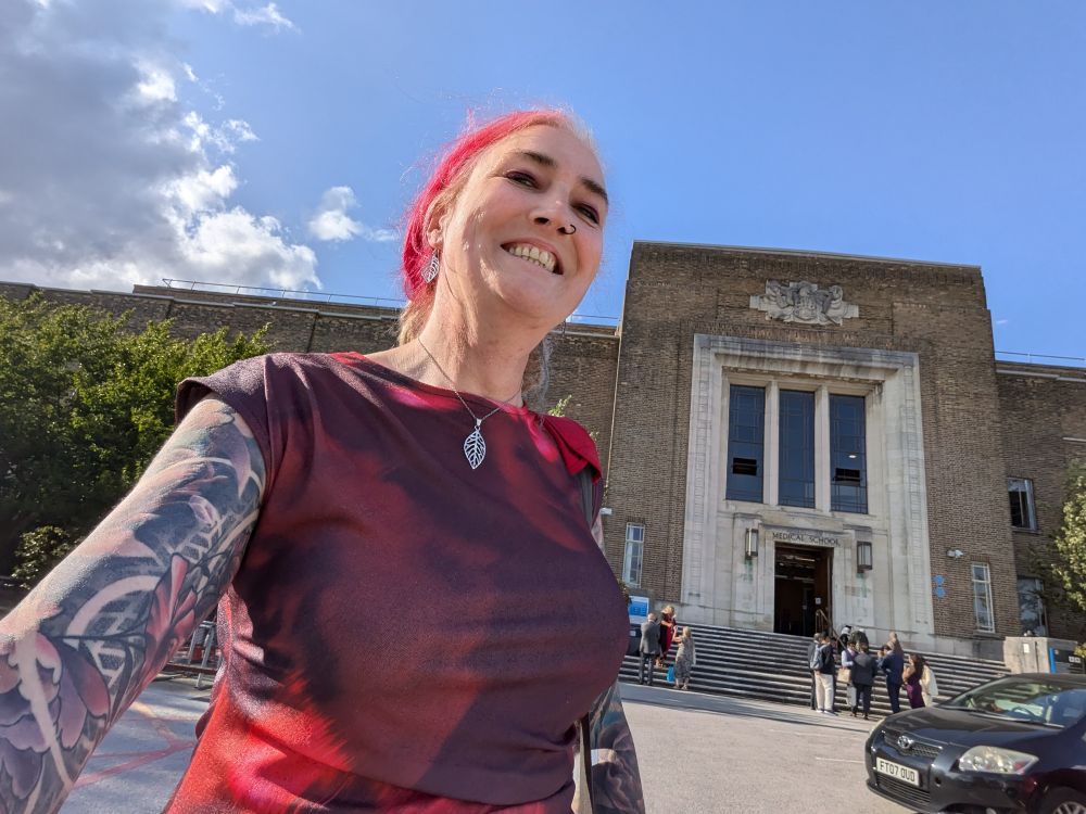 A very happy girl stood outside her new medical school