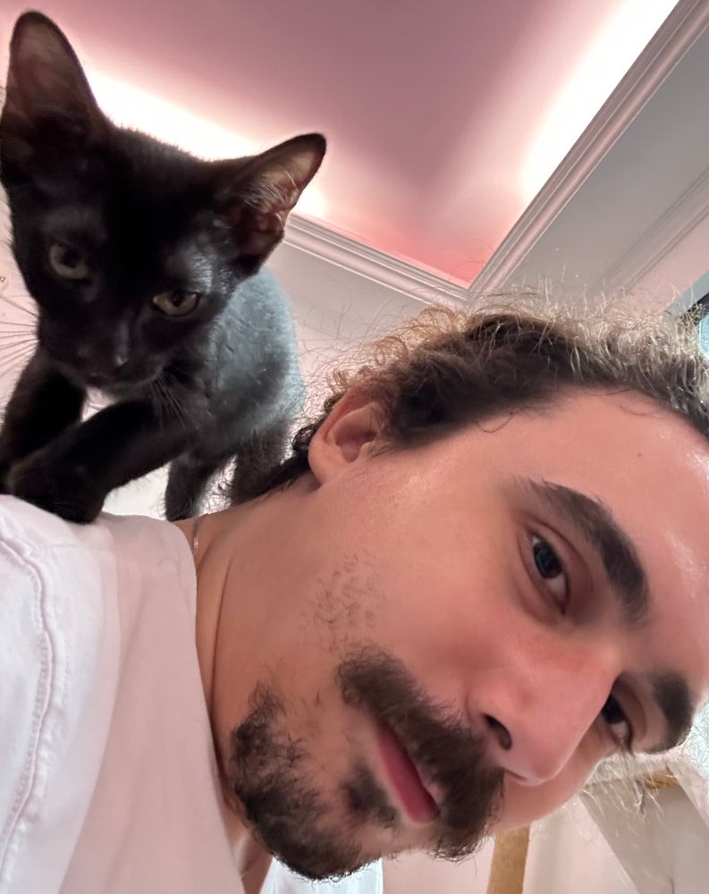 Foto minha com um gato filhote preto nos meus ombros