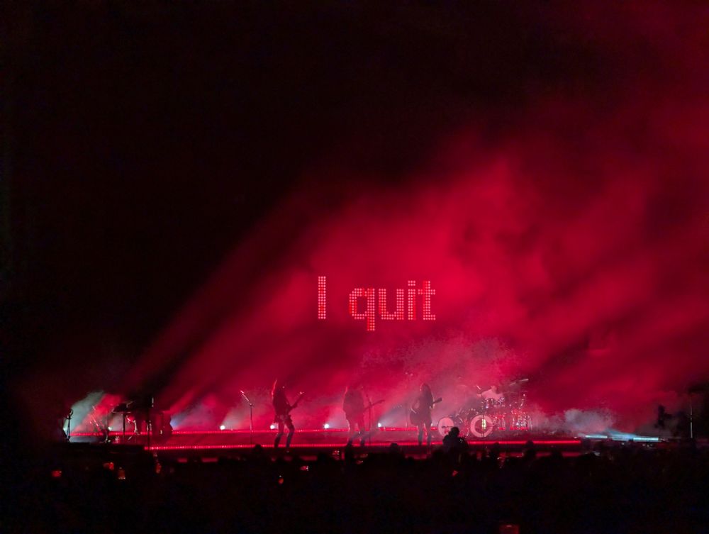 Photo of the stage tonight for the Haim show at the Rady Shell on the embarcadero in San Diego with the words I quit displayed against red lights and fog