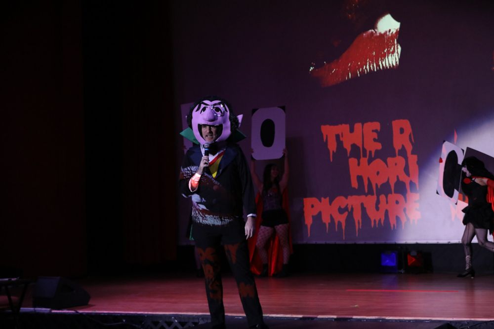 me as count von count again, yelling at the audience while "R" and "O" and "C" signs are visible behind me ("give me an r... give me an o...")