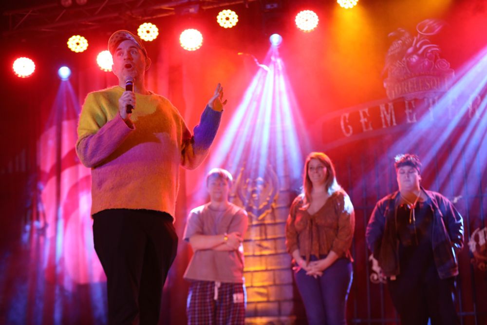 Me on stage, running a game, with three slightly blurry audience participants visible in the background.