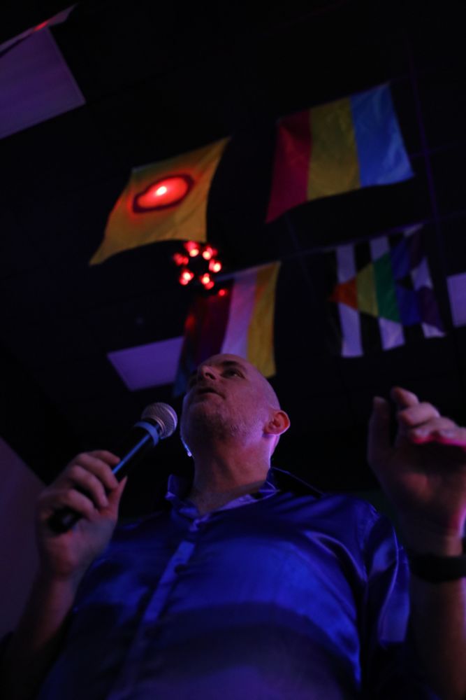 Me, shot from the ground, showing the ceiling of Radclyffe's with the various pride flags including Intersex, Pansexual, NonBinary, and Ally.