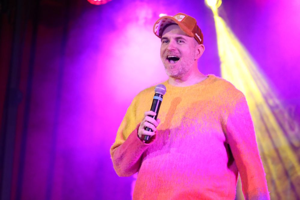 Me, looking very loud and speaking in a microphone with some bright purple stage lighting