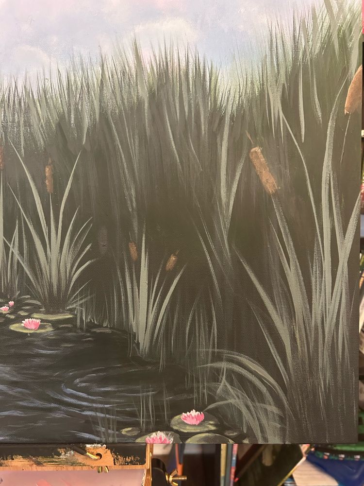 A boat on a pond surrounded by cattails and lily pads  