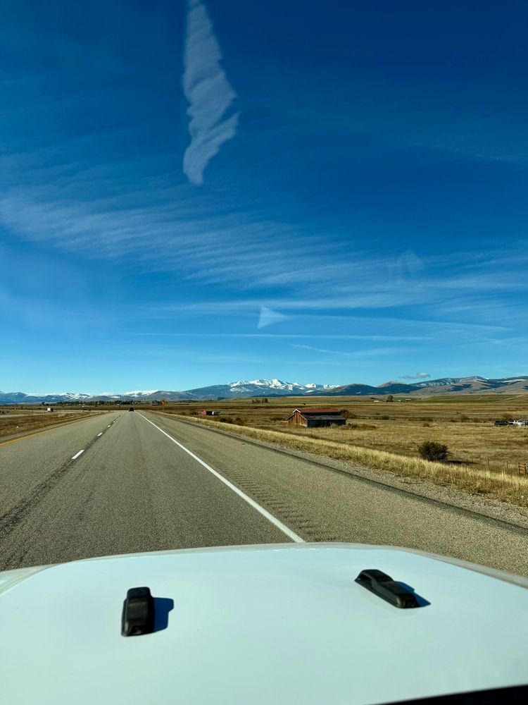 The same view once more only there’s no clouds this time and it’s wide open with golden fields stretching out to view snow on the Pintlers
