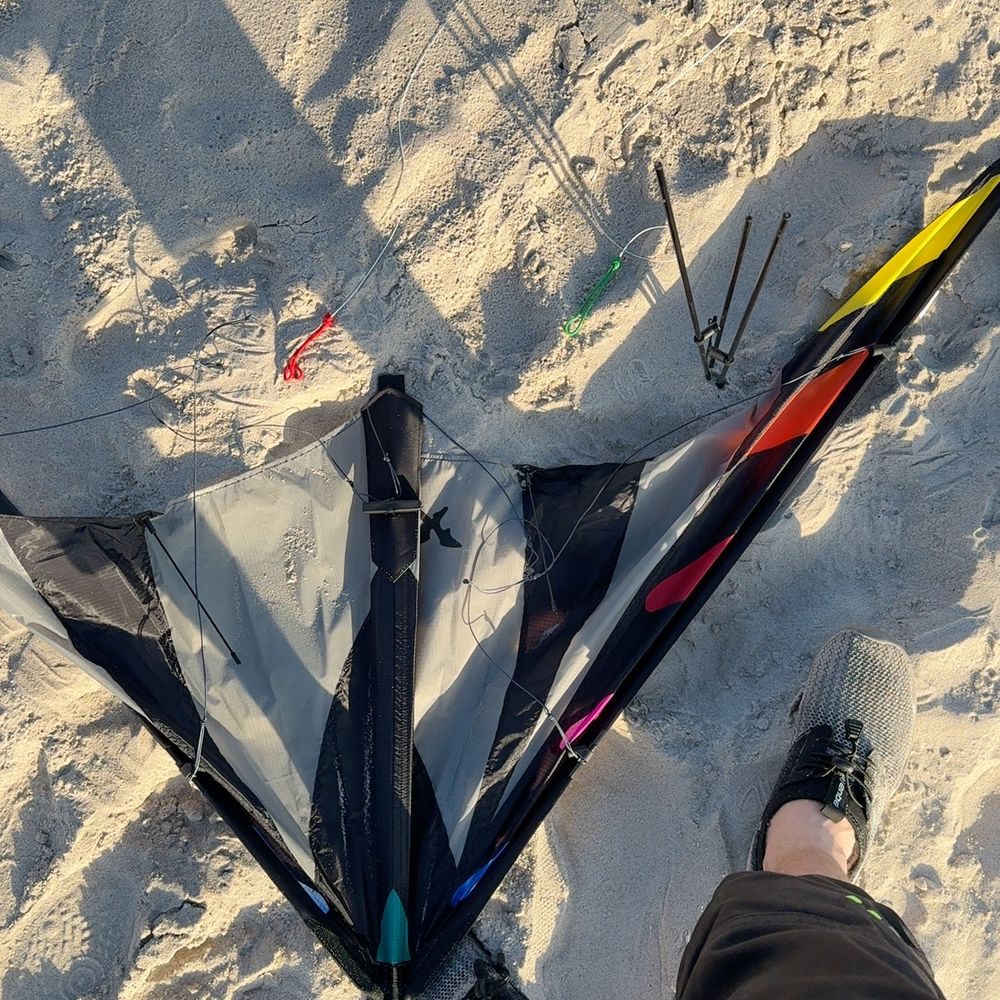 Mein Lenkdrache nach dem Steigen lassen und kurz vorm zusammenpacken im Sand am Strand