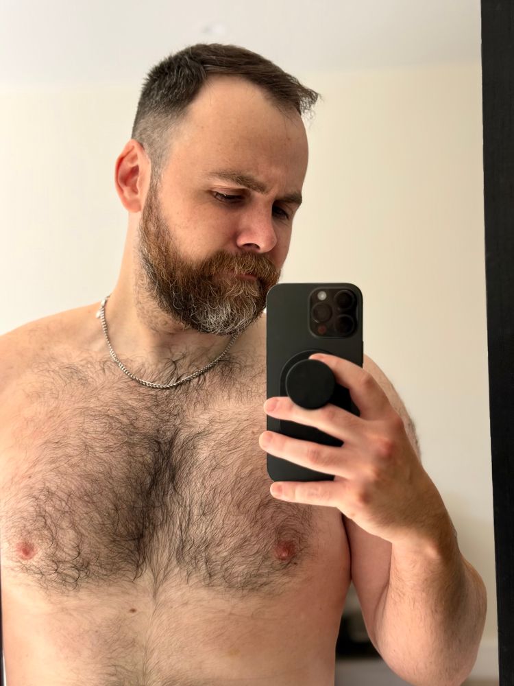 Selfie of shirtless man in bedroom 