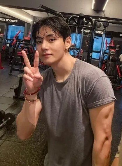 buff taehyung making a peace sign, he has a little smile on his face