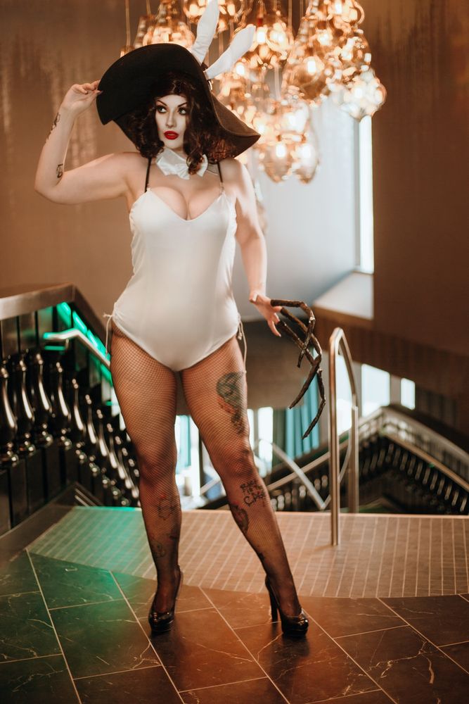 Villanarei cosplay Lady Dimitrescu in a white bunnysuit, fishnets, and heels