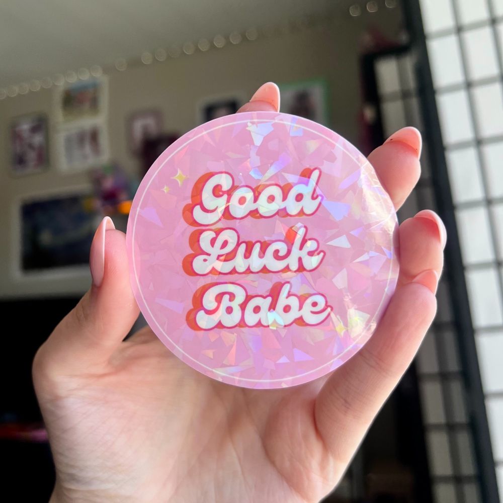 Round pink holographic sticker that says Good Luck Babe
