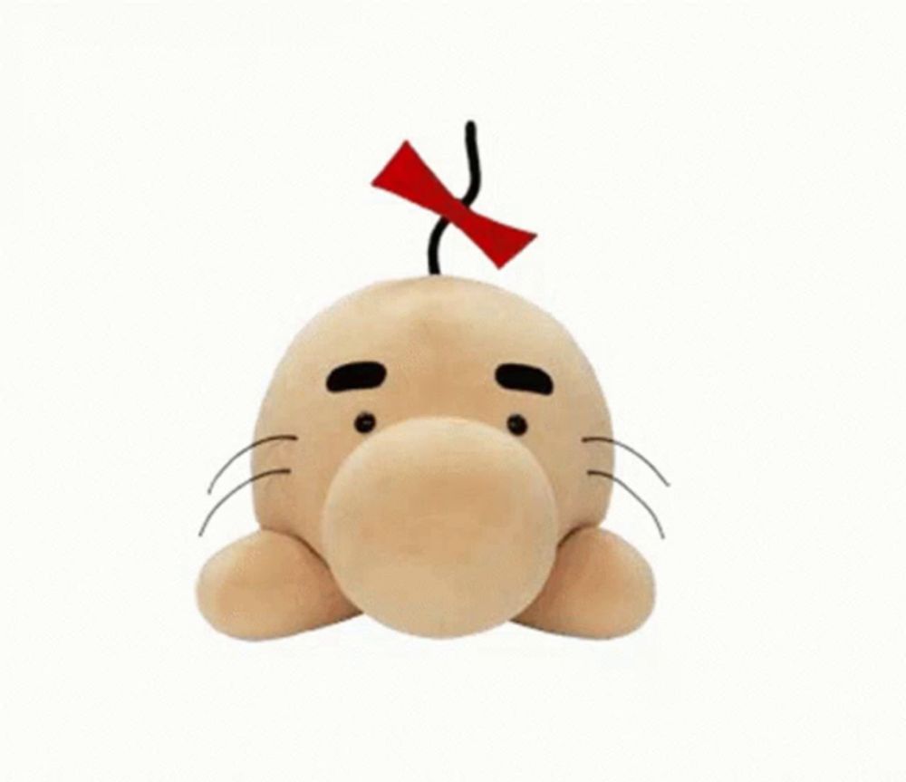 a stuffed cartoon character with a red bow on its head