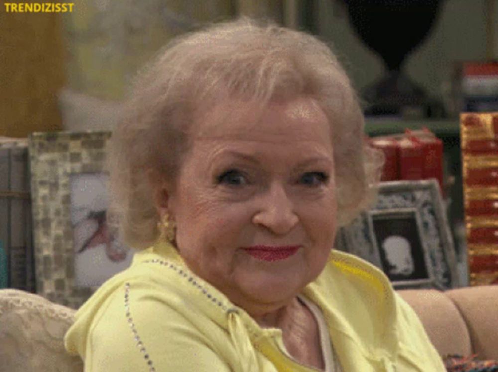 a woman in a yellow sweater is sitting on a couch with a picture frame in the background