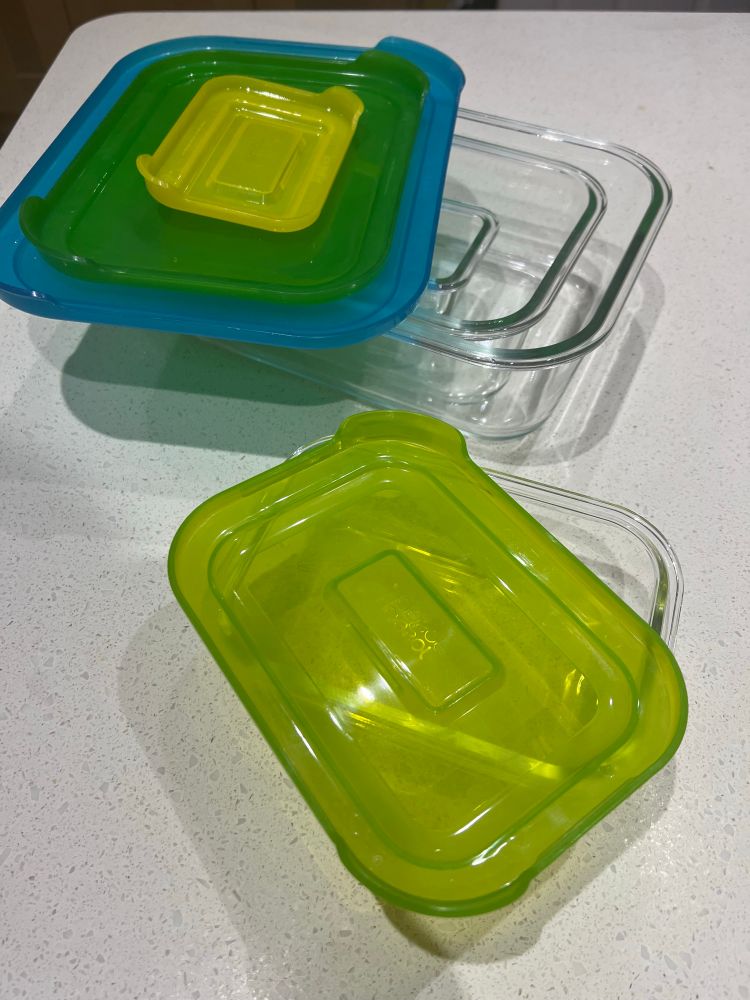 A set of nesting glass food containers, with separate nesting lids, one from the middle on its own in the foreground. Not pictured: our really hard kitchen floor that I desperately try not to drop them on while trying to insert one into the middle of the stack.