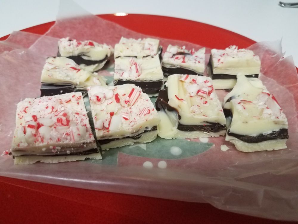 Pieces of homemade peppermint bark on a red Christmas plate.