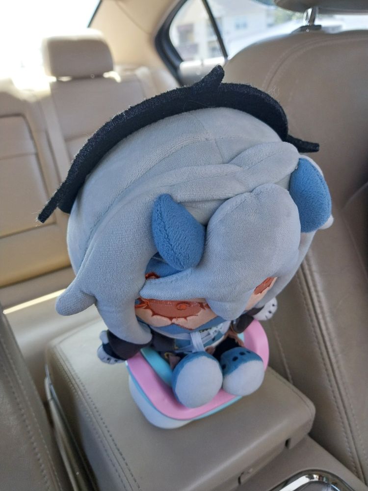 makeship chaos sitting in the booster seat, buckled up. he looks like hes sad but thats just because his head is too big for his own good.