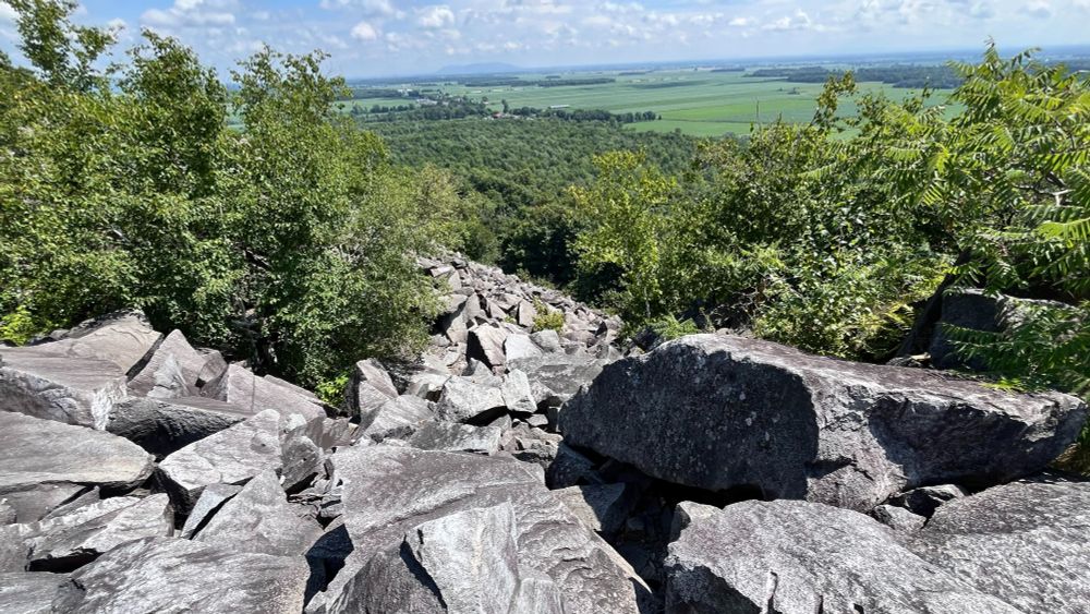 Un éboulis de roches témoigne de l'impact de l'ancienne carrière qui a fait perdre à la montagne tout un flanc. 