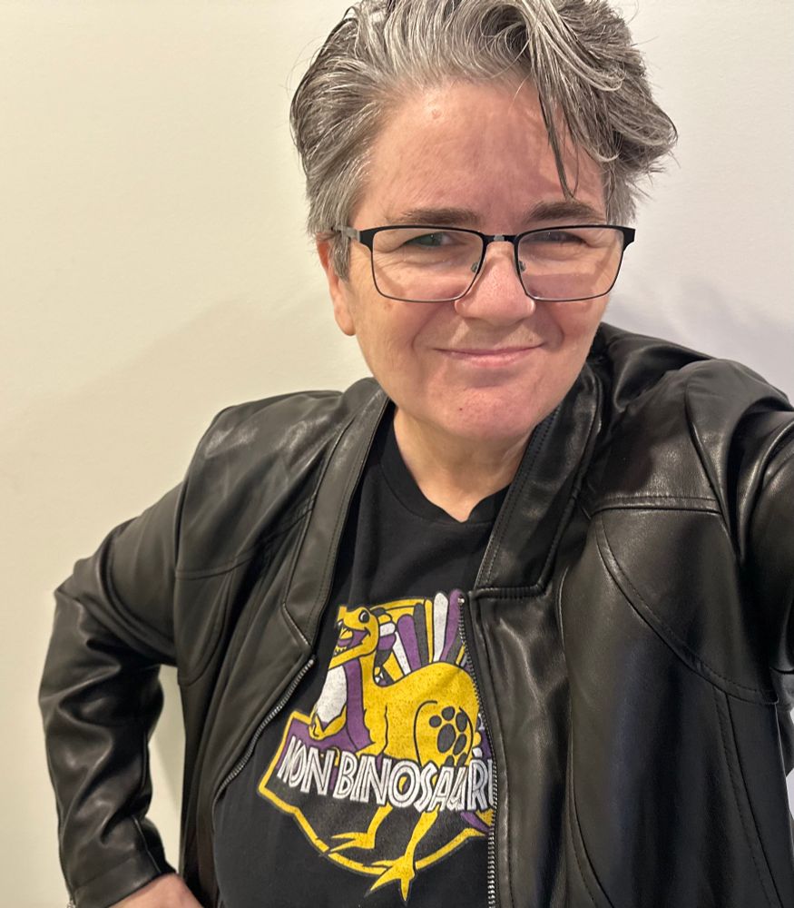 59 year-old Aboriginal trans/non-binary person in a selfie wearing a nonbinosaurus shirt. 