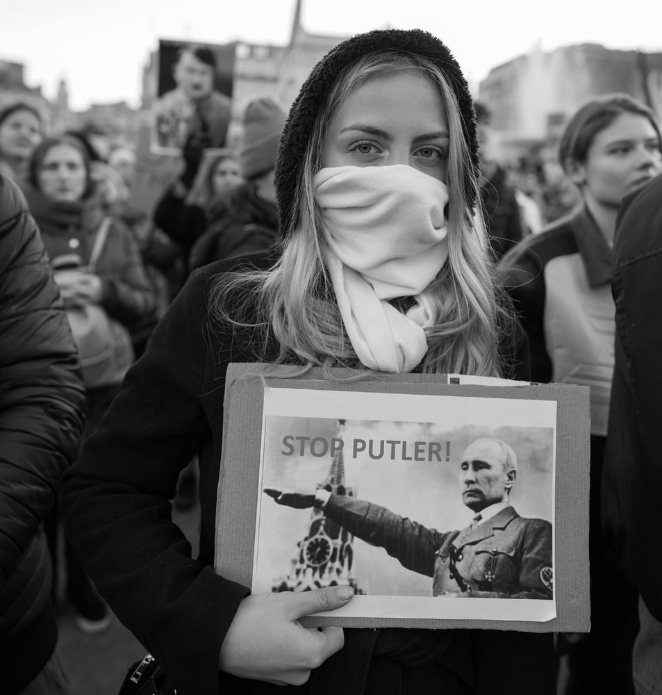 Russian woman holding a sign saying “Stop Putler”