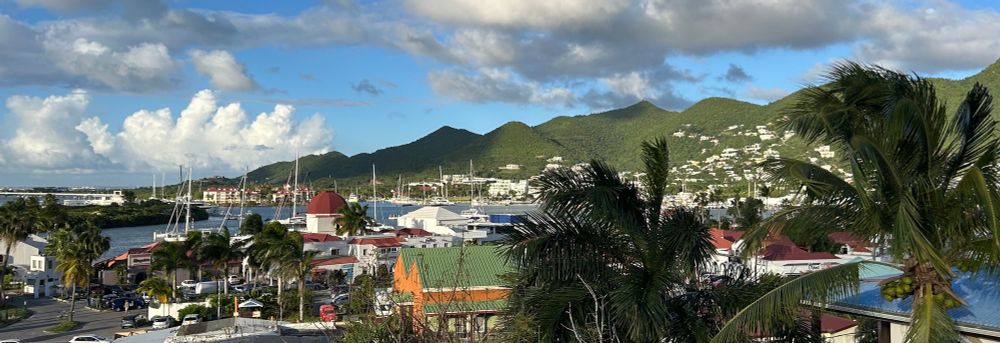 The eastern end of Simpson Bay lagoon, with many masts of sailboats docked at several marinas visible. 
