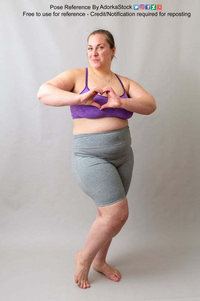 Fat white woman standing cutely holding her hands in a heart shape.