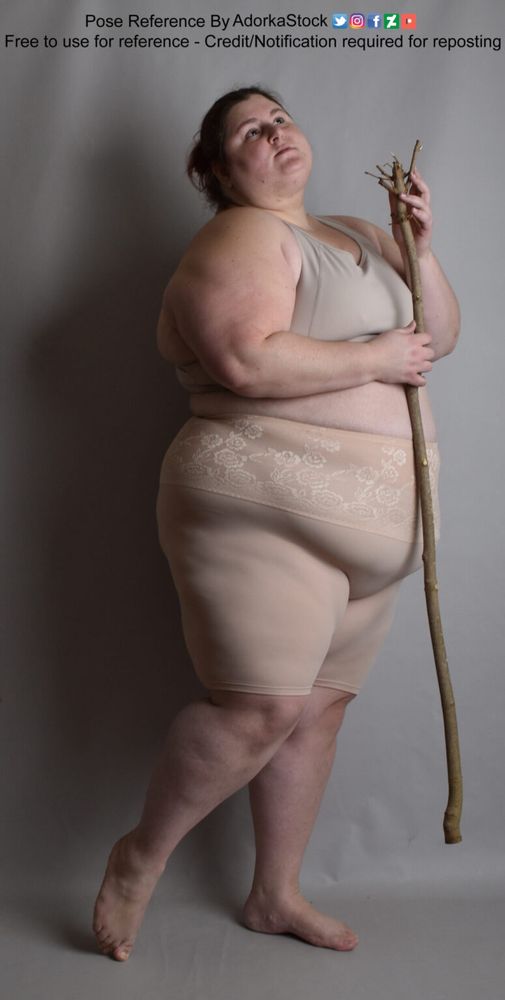 fat white female model in a profile pose holding a magical looking stick, looking over her shoulder
