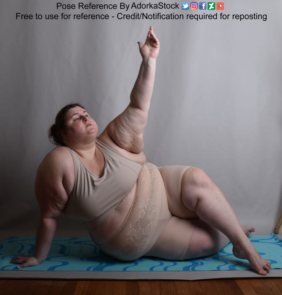 Pose reference of a fat, white, female model in a sitting pose on the floor, one hand supporting her upper body while the other hand is raised in a delicate gesture over her. Her left leg is crossed over her right which is on the floor. Her gaze is off into the sky.