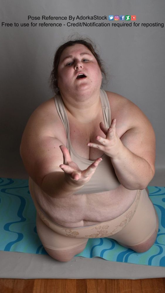 A fat white woman reaching upward towards the camera.
