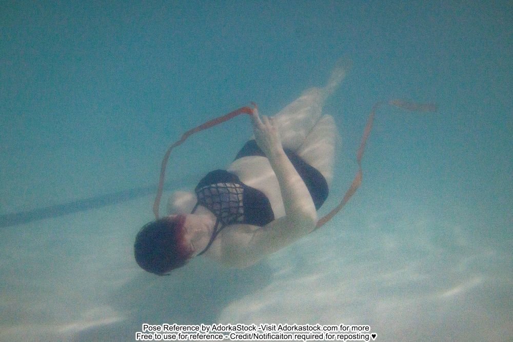 murky underwater photo of a model with the head closer to the camera, feet farther away, spinning with ribbons 