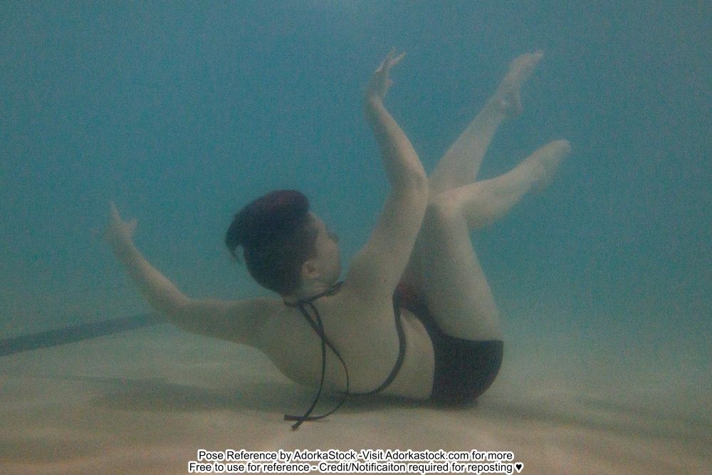 murky underwater photo of a model with her back to the floor arms and legs freefloating
