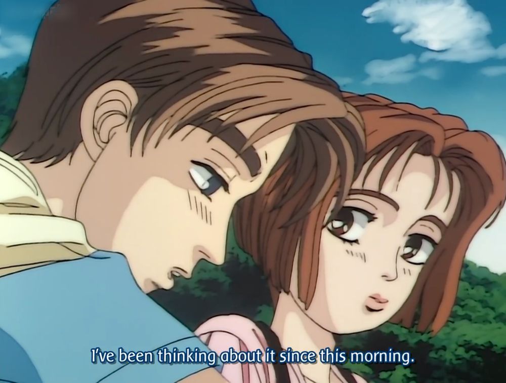 Takumi ja Mogi, molemmilla poskilla rusotusviivat, alaripset ja töröhuulet. Kaksi hahmoa keskustelevat luonnon helmassa.