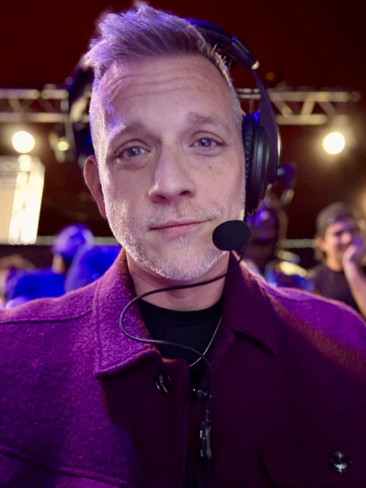 Christopher wearing a headset backstage at a wrestling show.