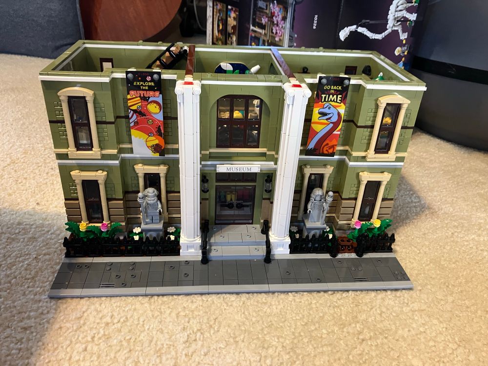 First two floors of LEGO History Museum with banners advertising space and dinosaur exhibits 