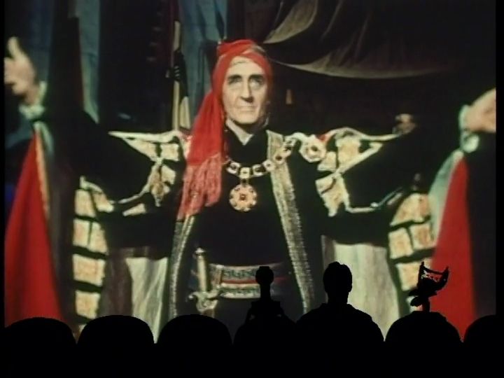 Basil Rathbone, playing an evil wizard, shows off his cape and his fineries.