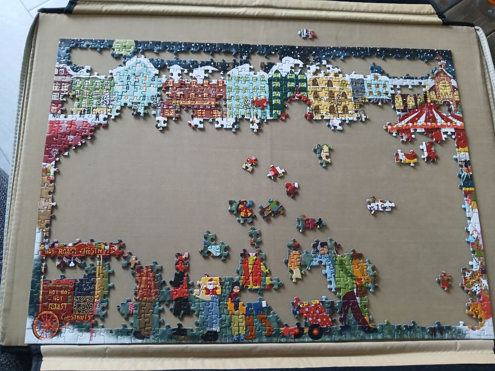 Oben sind die Häuser fertig und unten ein Stand und ein paar Menschen 