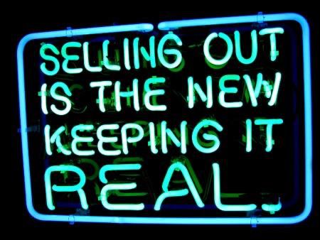 a neon sign i believe is by patrick martinez that reads "SELLING OUT IS THE NEW KEEPING IT REAL"