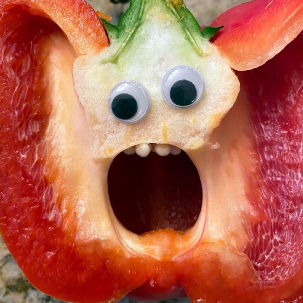 Half red bell pepper with googly eyes appears to be screaming in horror. 