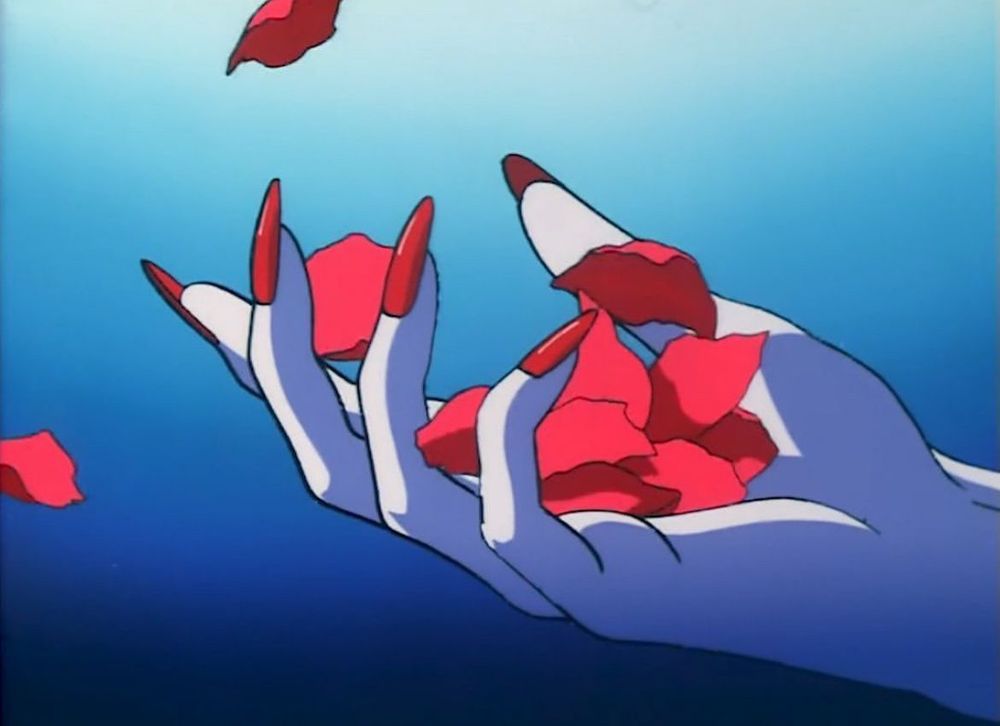 a white hand with long red nails reaches across a blue background releasing rose petals 