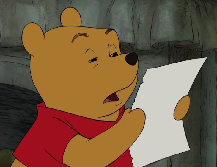 Winnie the pooh squinting at a paper