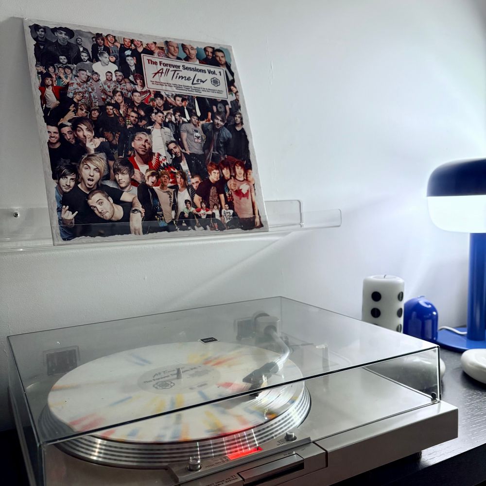Confetti varient of the record The Forever Sessions Vol. 1 by All Time Low playing on a record player. 