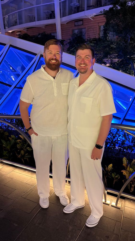 Beared ginger and his husband dressed in all white for a cruise theme night