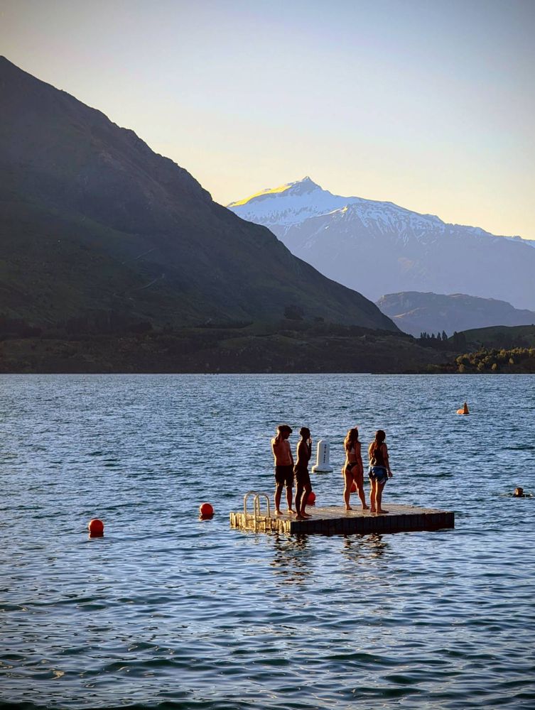 Youth out on a swim pontoon as the sun goes down. While a warm day the lake temperature will barely into double digits.