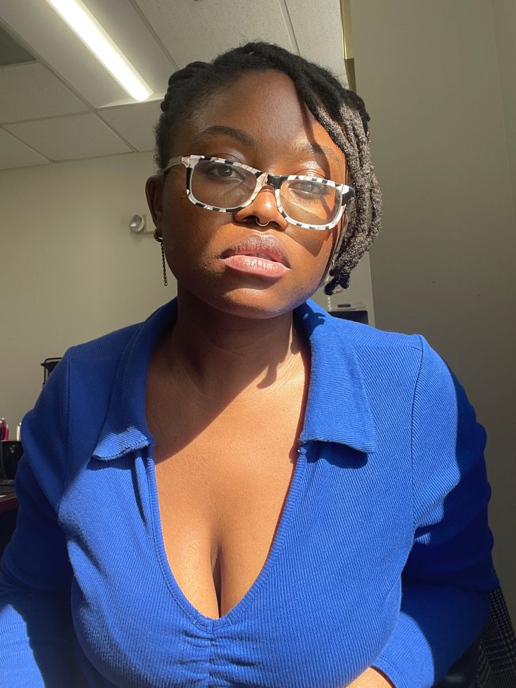 Selfie of a Black femme in a blue top 