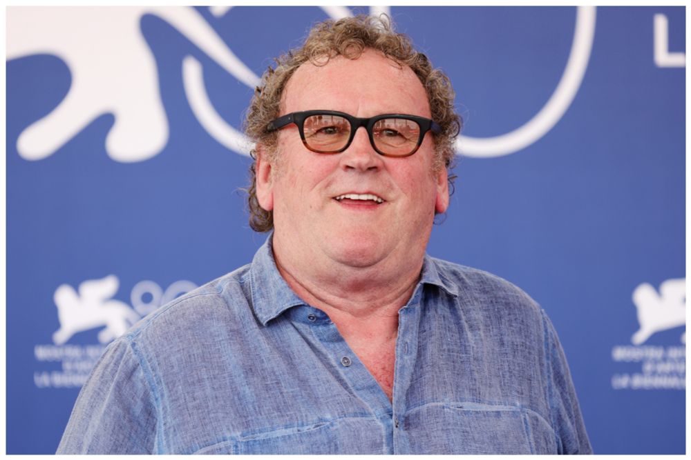 Colm Meaney, wearing black glasses and looking jolly 