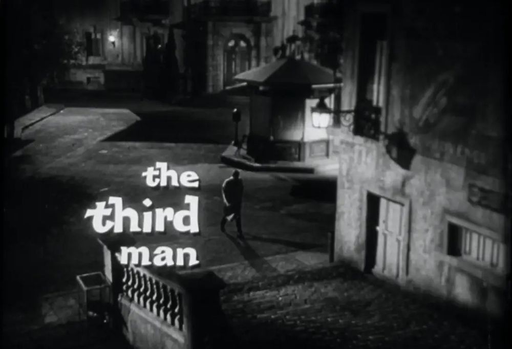 Still from The Third Man. Night scene of a man walking through city streets. 