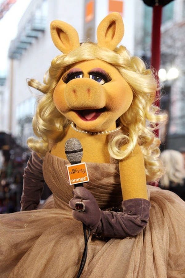 Miss Piggy, holding a microphone 