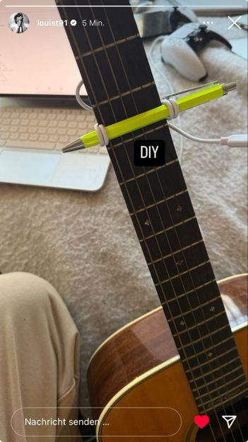 A selfmade capo of a pen and a cable on an acoustic guitar posted by Louis Tomlinson 
