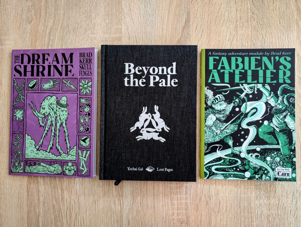 One book and two zines on the table: Beyond the Pale in the middle, The Dream Shrine on the left, and Fabien's Atelier on the right