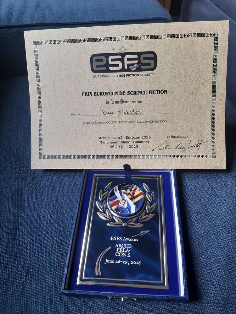 Urkunde und Award der ESFW Awards. Der Award ist eine dunkelblaue Plakette mit dem Logo der Archipelacon, die einen Vogel in Piratenuniform zeigt. Die Urkunde ist auf beigem Papier und weist auf Französisch den Gewinn in der Kategorie Bestes Magazin aus.